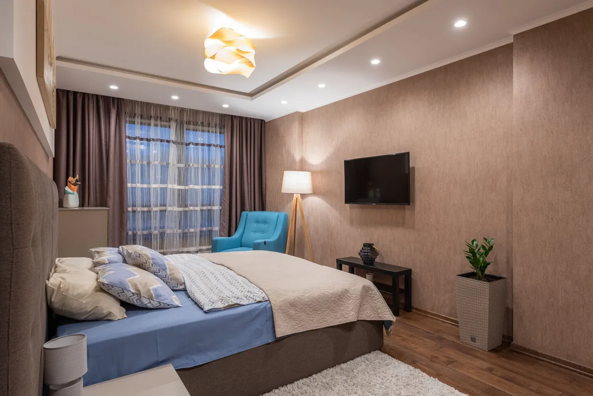Inviting bedroom featuring a comfortable bed, cozy furnishings, and elegant lighting.