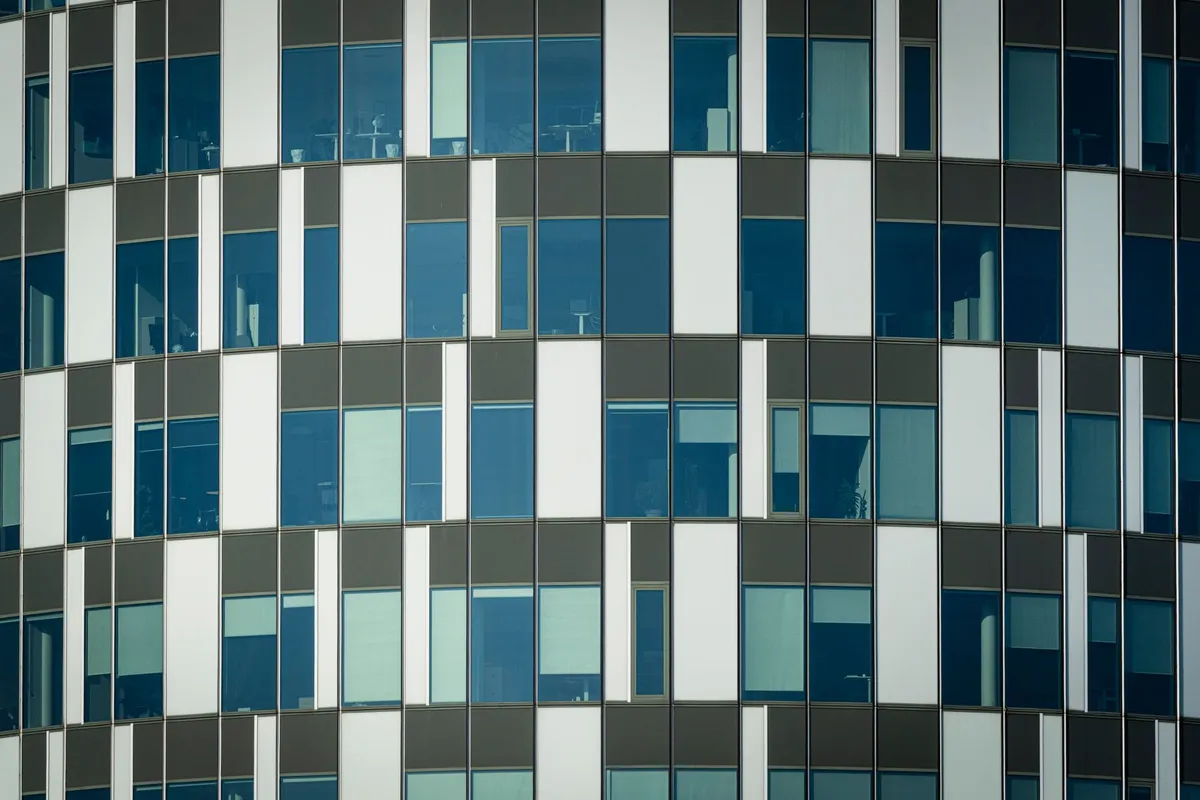 Close-up of a modern office building facade with geometric patterns and glass windows.