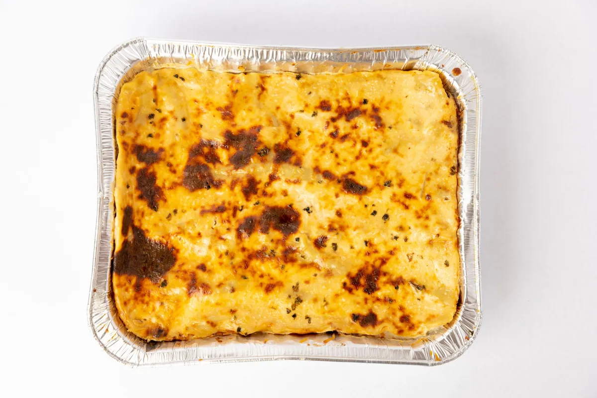 A freshly baked lasagna with golden cheese crust captured from above in a foil tray.